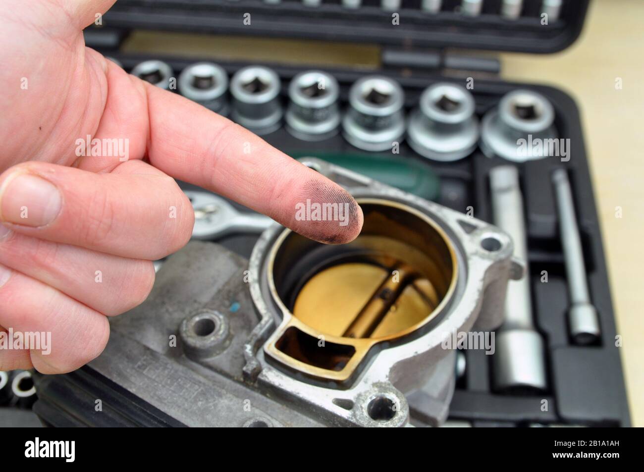 Repair and cleaning the car throttle. Throttle with traces of burning and soot on the background of a set of tools for car repair Stock Photo