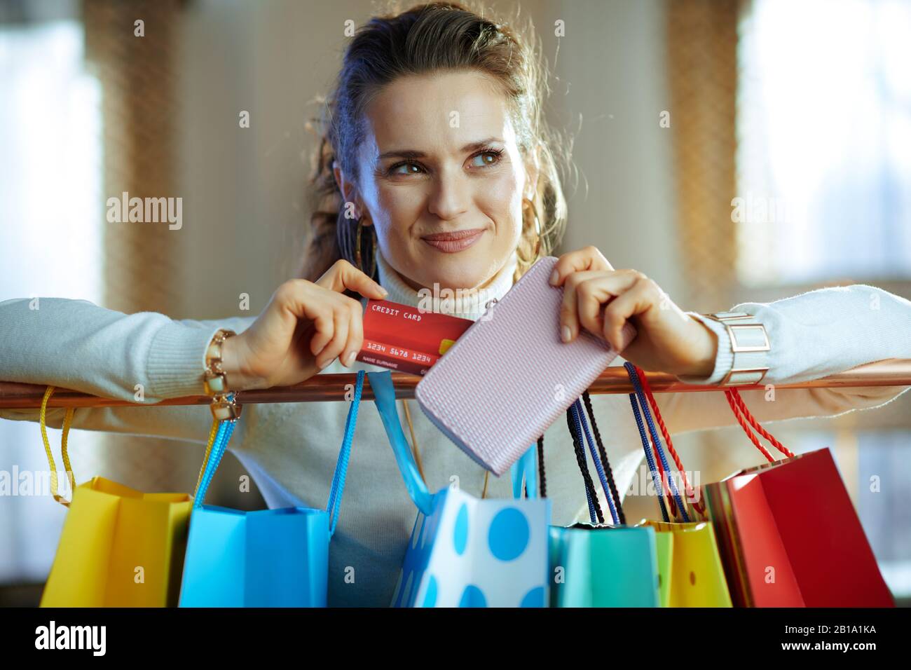 happy stylish 40 years old woman in white sweater and skirt near