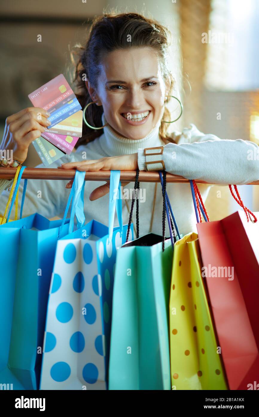 Portrait of smiling stylish 40 years old woman in white sweater and