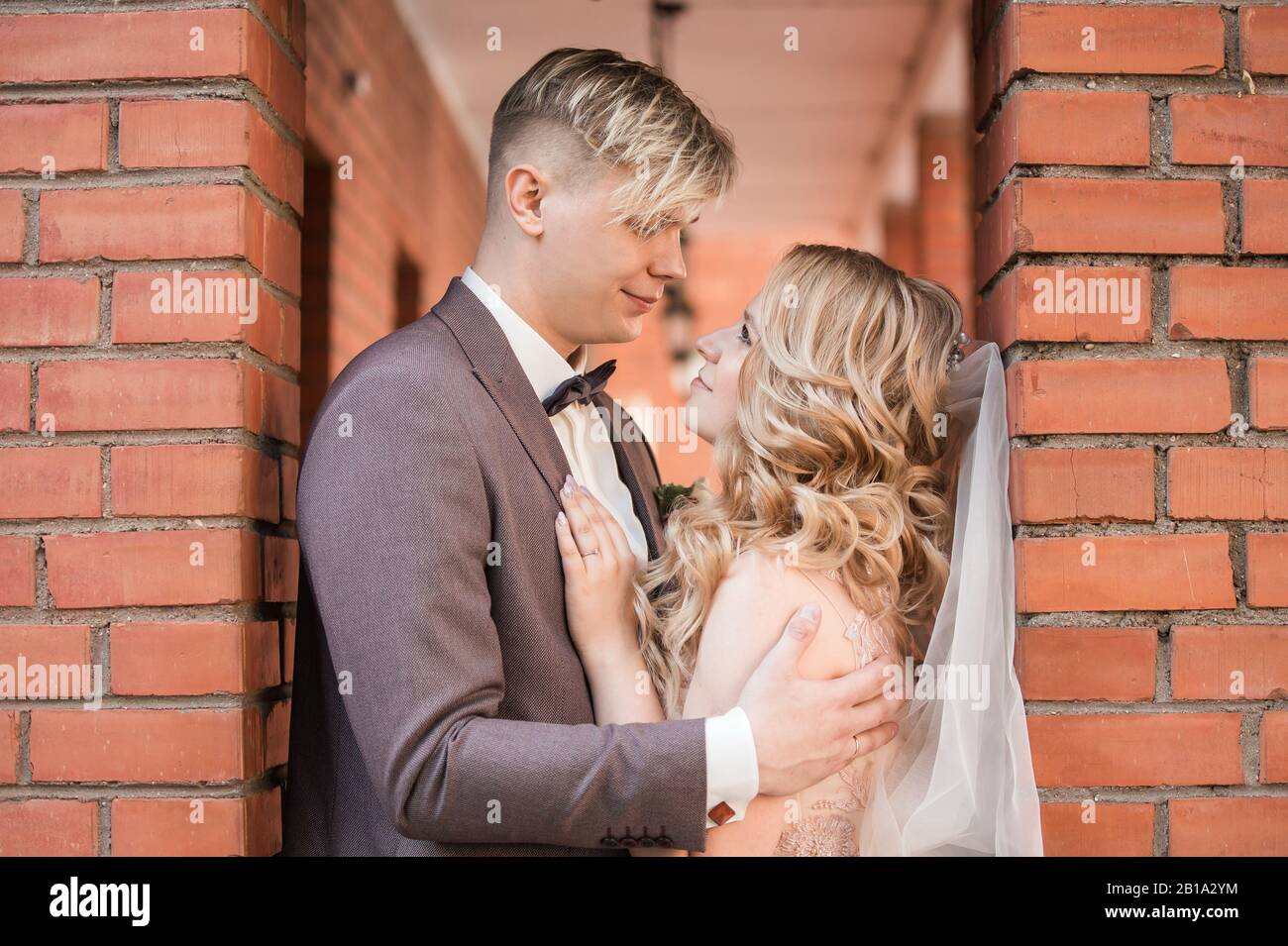happy newlywed couple hugging each other while walking Stock Photo - Alamy