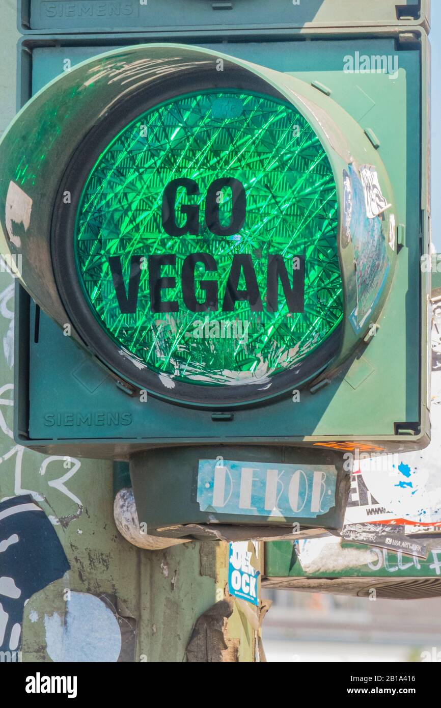 'go vegan', text on transparent film attached to green traffic light Stock Photo