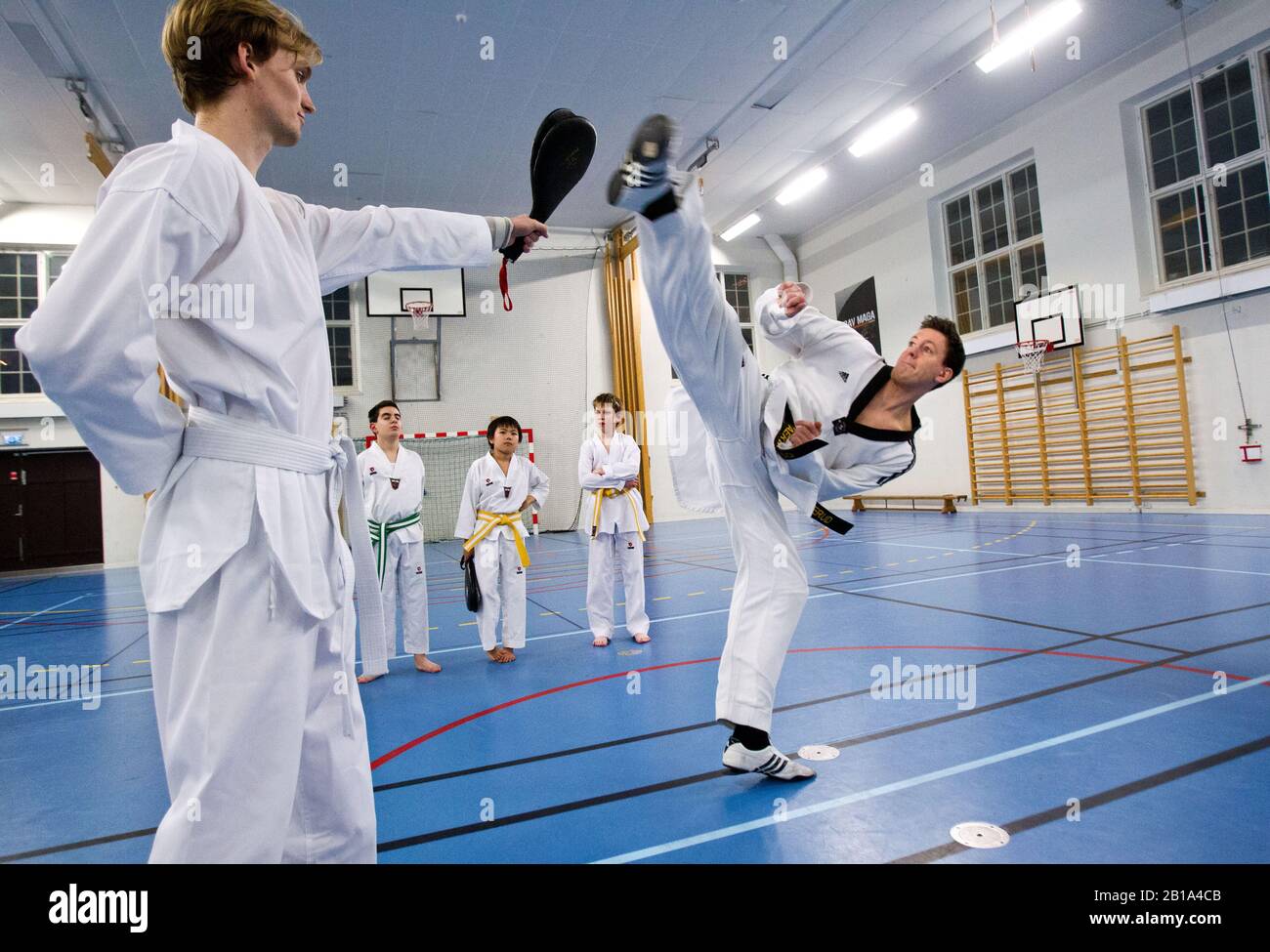 Young people practicing taekwondo. Taekwondo, Tae Kwon Do or Taekwon-Do is a Korean martial art, characterized by its emphasis on head-height kicks, jumping and spinning kicks, and fast kicking techniques.Photo Jeppe Gustafsson Stock Photo