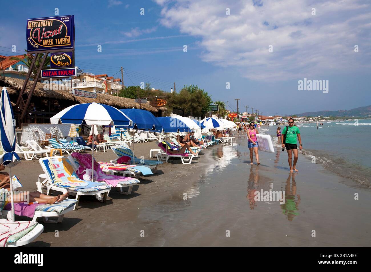 Urlauber am Sandstrand von Laganas, touristischer Ort auf der Insel Zakynthos, Griechenland | People at the beach of Laganas, Zakynthos island, Greece Stock Photo