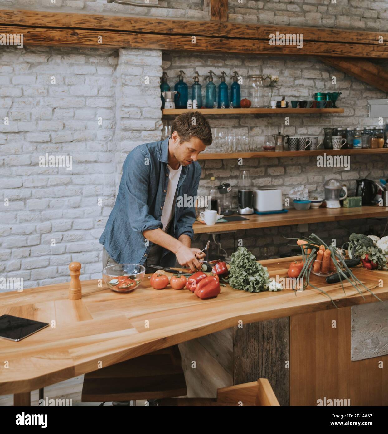 Young man preparing food in the rustic kitchen Stock Photo