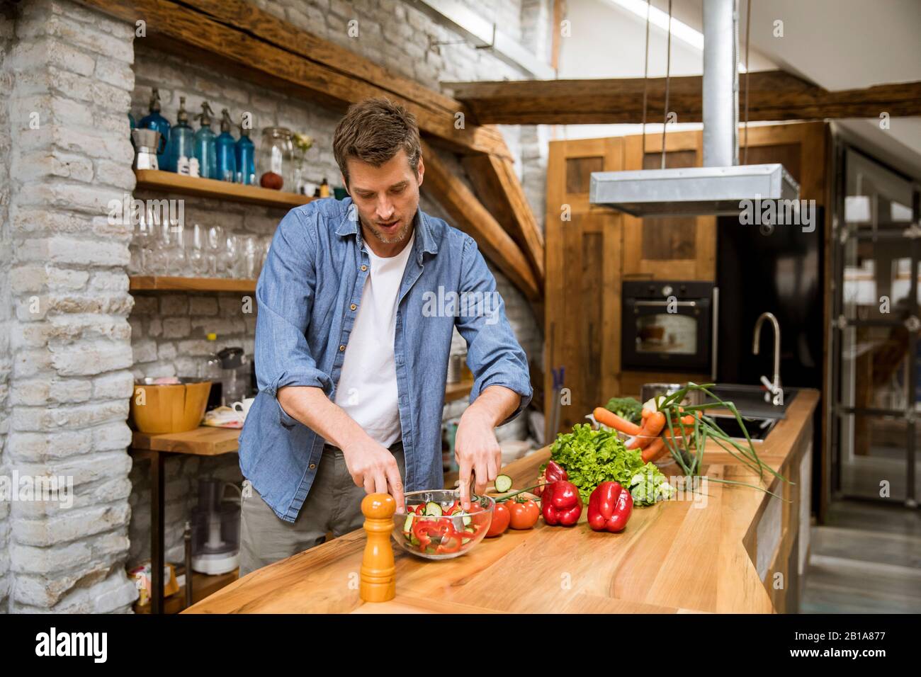 Young man preparing food in the rustic kitchen Stock Photo