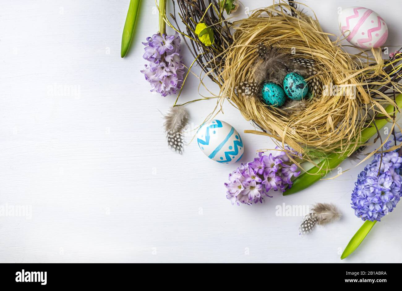 Easter. quail easter eggs in the nest. Hyacinths on white wooden background. with copy space Stock Photo