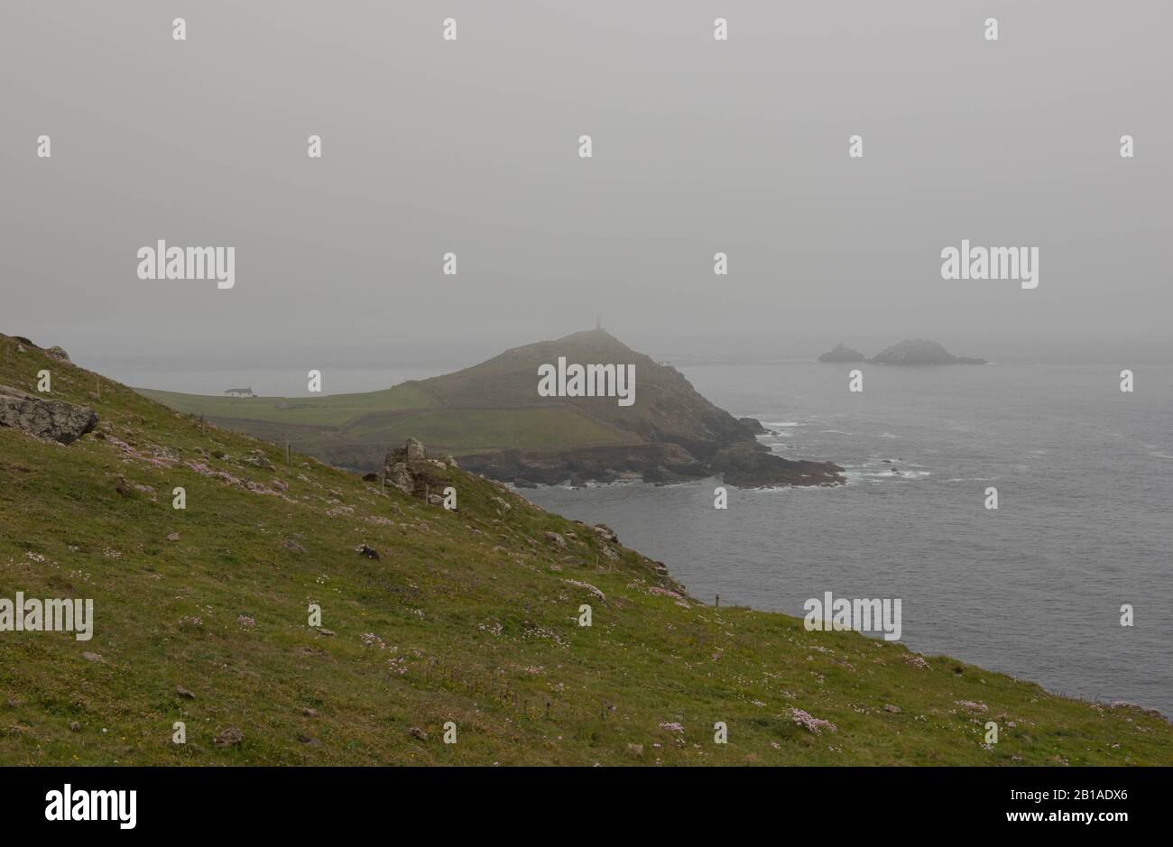 Headland of Cape Cornwall Shrouded in Sea Mist by the Atlantic Ocean on the South West Coat Path in Cornwall,England,UK Stock Photo