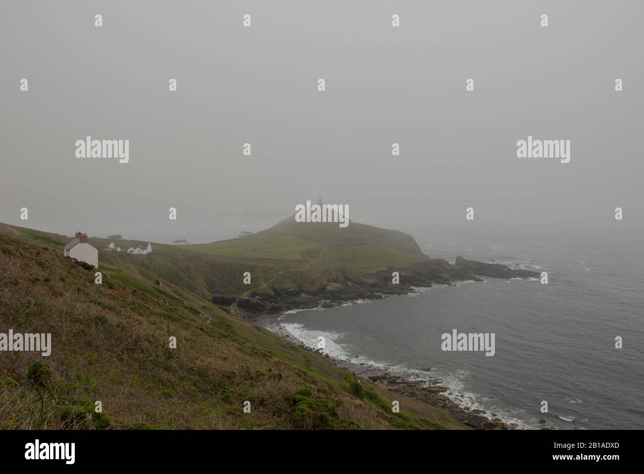 Headland of Cape Cornwall Shrouded in Sea Mist by the Atlantic Ocean on the South West Coat Path in Cornwall,England,UK Stock Photo