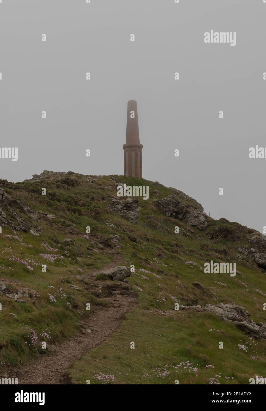 Chimney or Tower Monument on the Summit of Cape Cornwall Shrouded in Sea Mist on the South West Coast Path in Rural Cornwall,England,UK Stock Photo