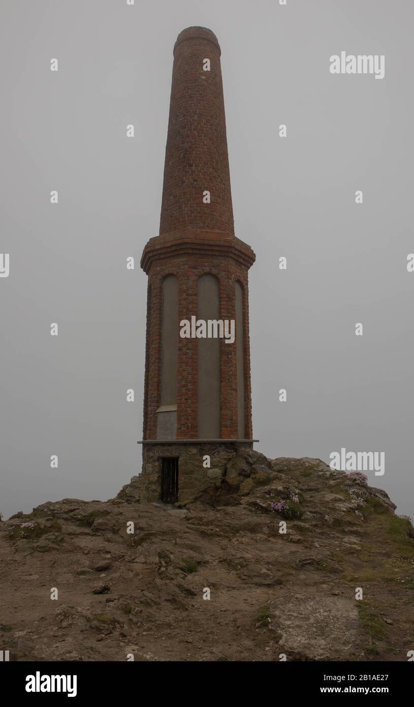 Chimney or Tower Monument on the Summit of Cape Cornwall Shrouded in Sea Mist on the South West Coast Path in Rural Cornwall,England,UK Stock Photo