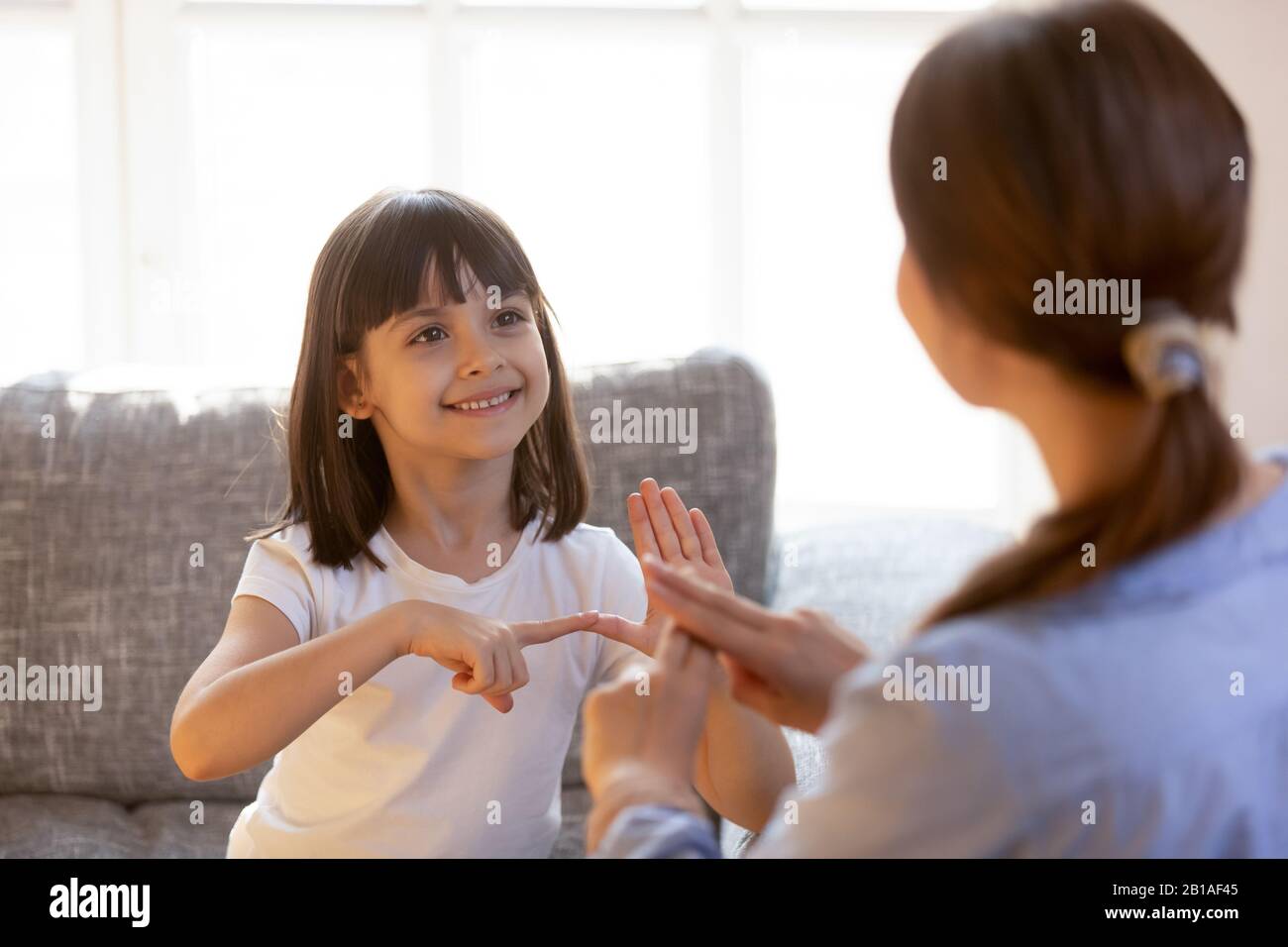 Cute little girl practice sign language with teacher Stock Photo