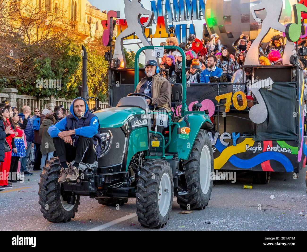 Workers of the Carnival of Viareggio, Italy, take care of the tractor that carries the allegorical float in a parade Stock Photo