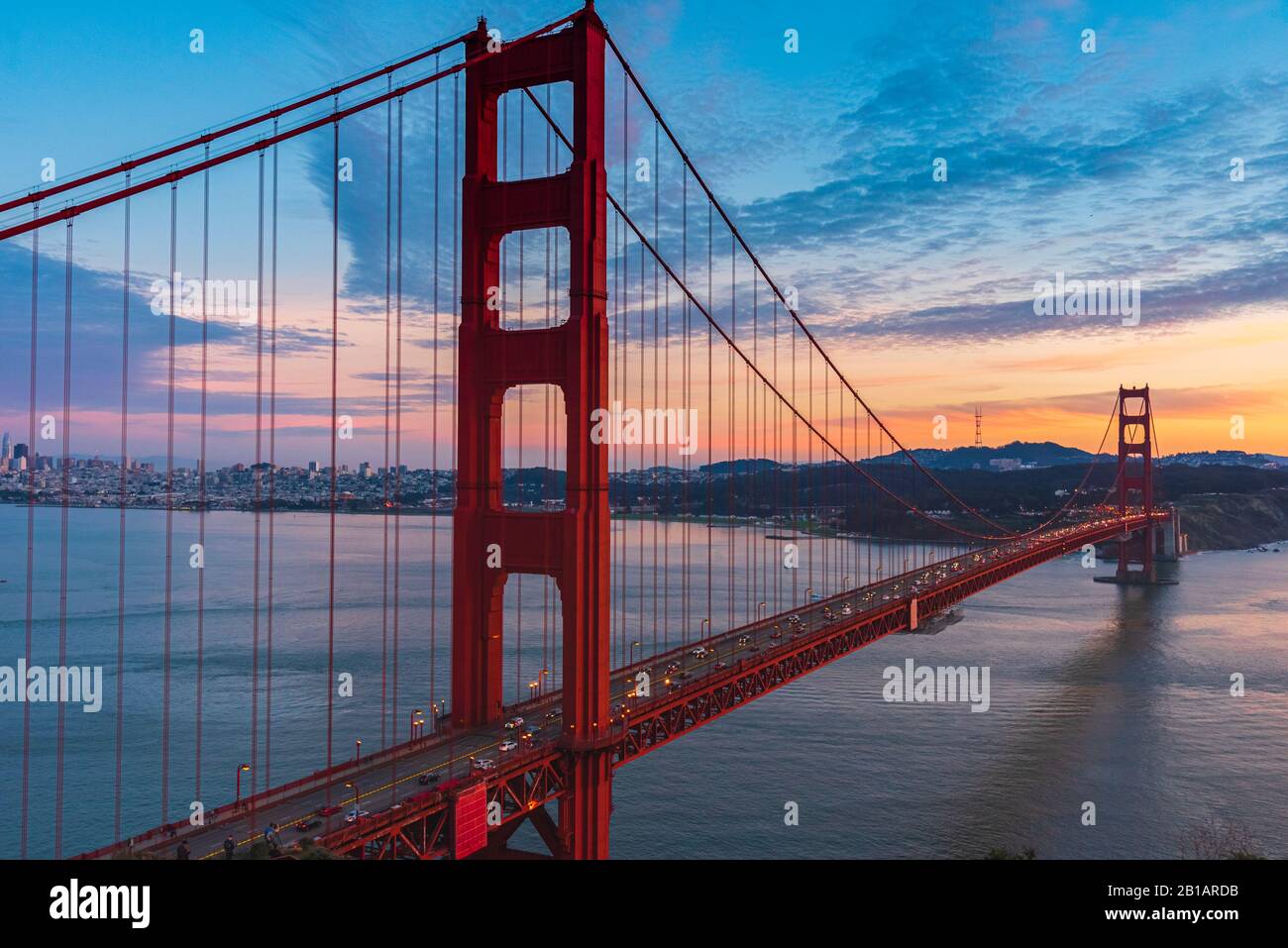 View of the Golden Gate Bridge at night with lights reflections in the ...