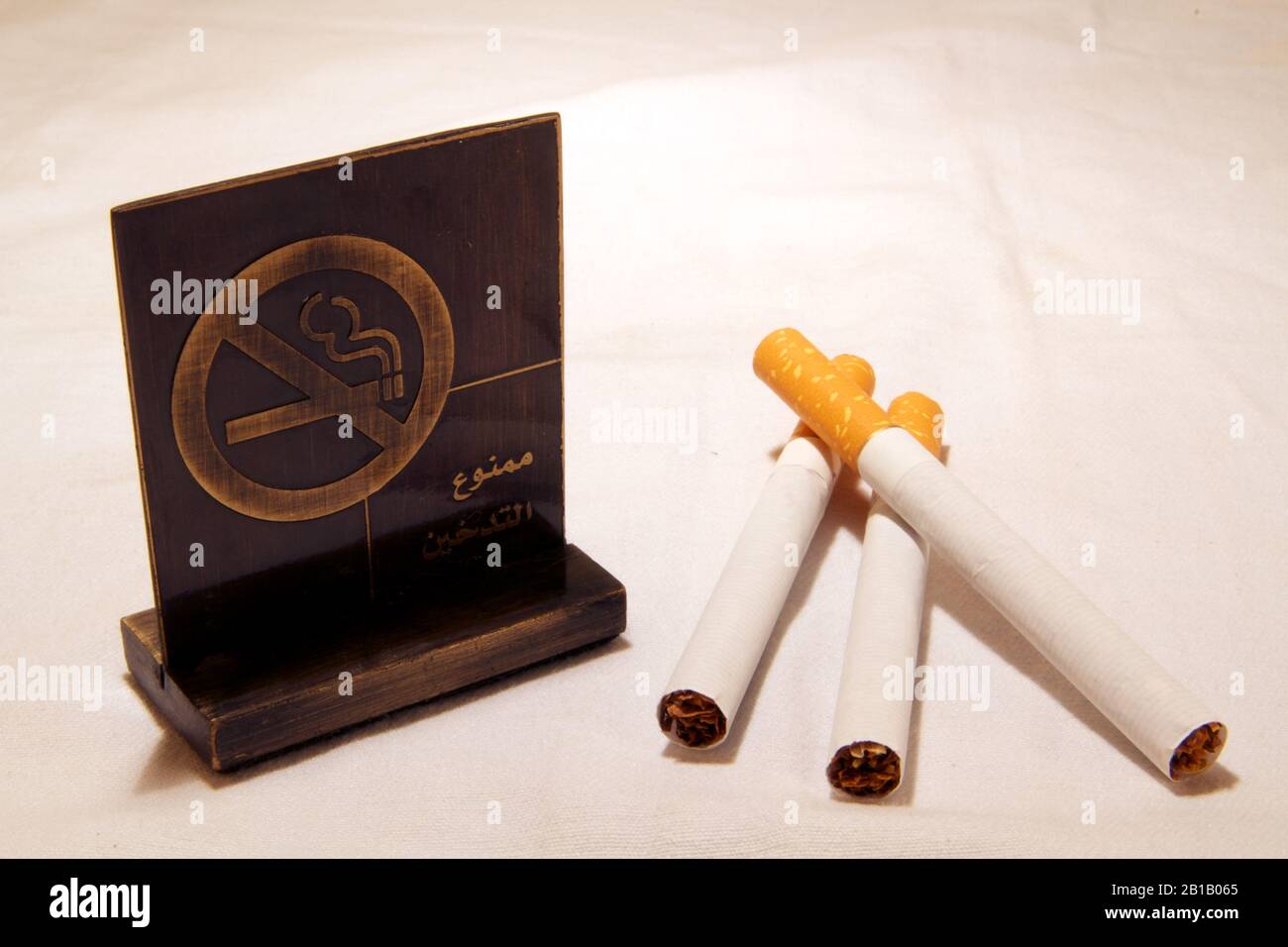 Dubai-No smoking metal tag with cigarettes on the table 19 Stock Photo