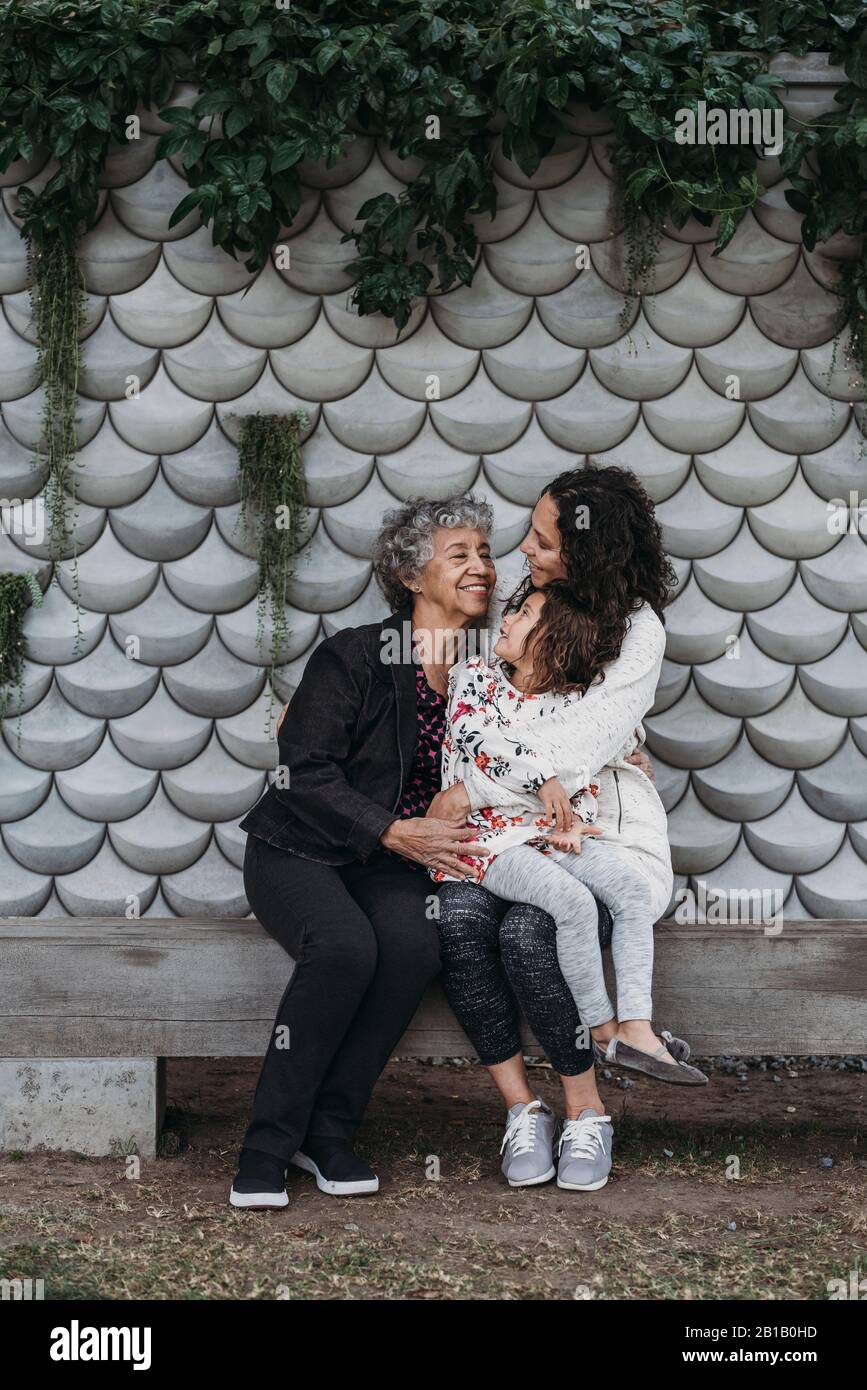 Portrait of multigenerational women sitting and smiling outside Stock Photo
