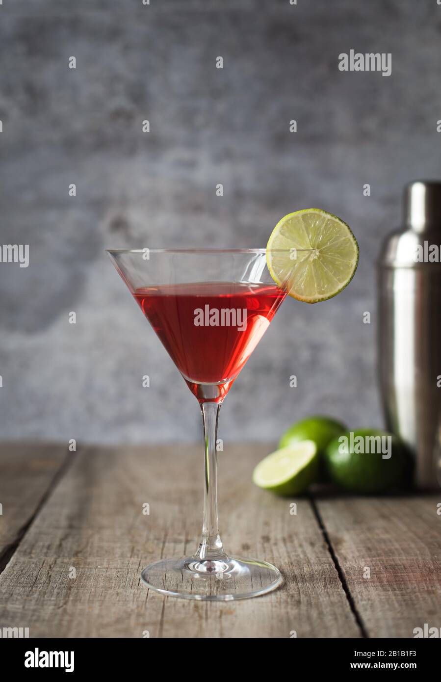 Close up of cosmopolitan martini drink and shaker on wood table. Stock Photo