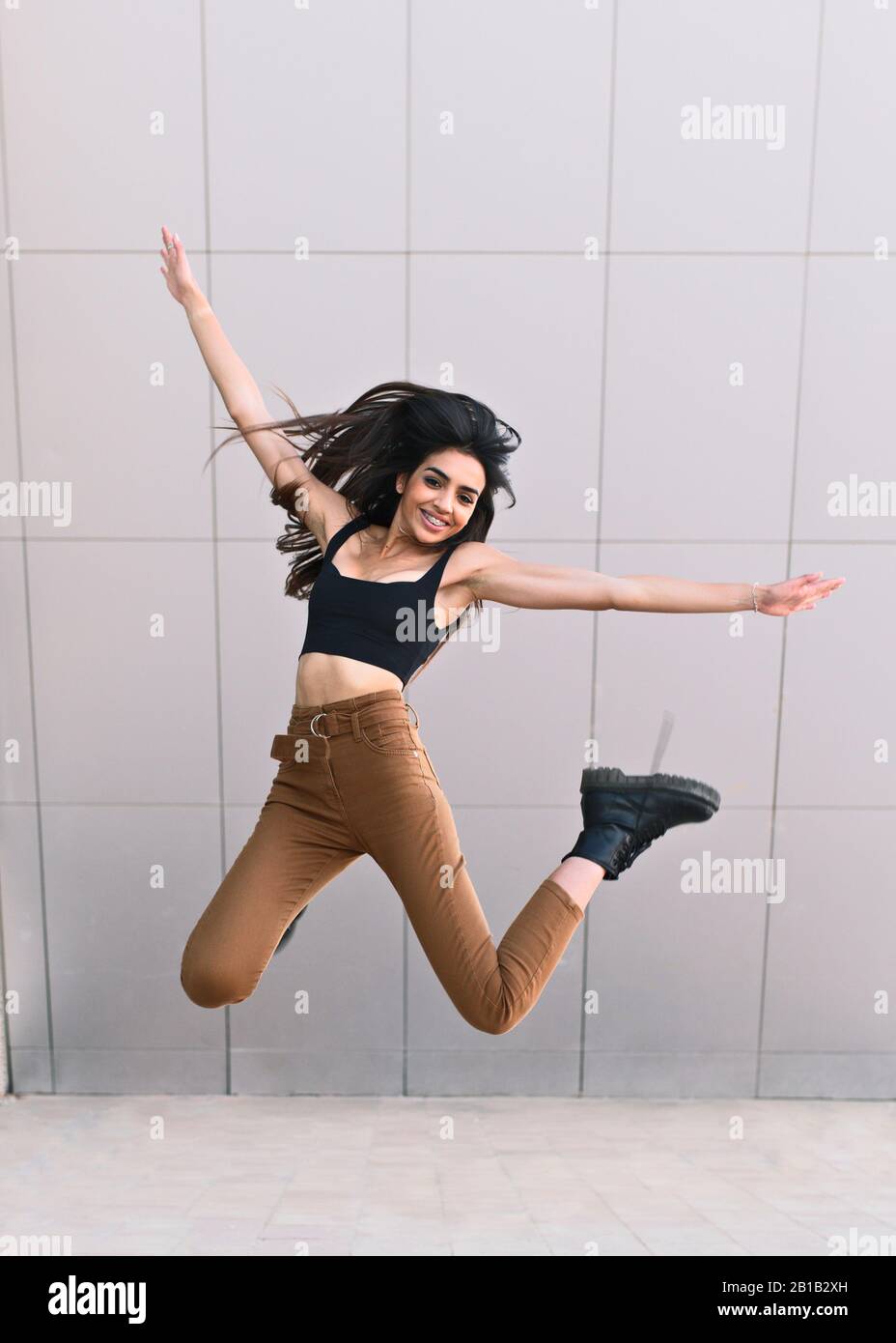 Young Arabian girl jumps happily outside Stock Photo