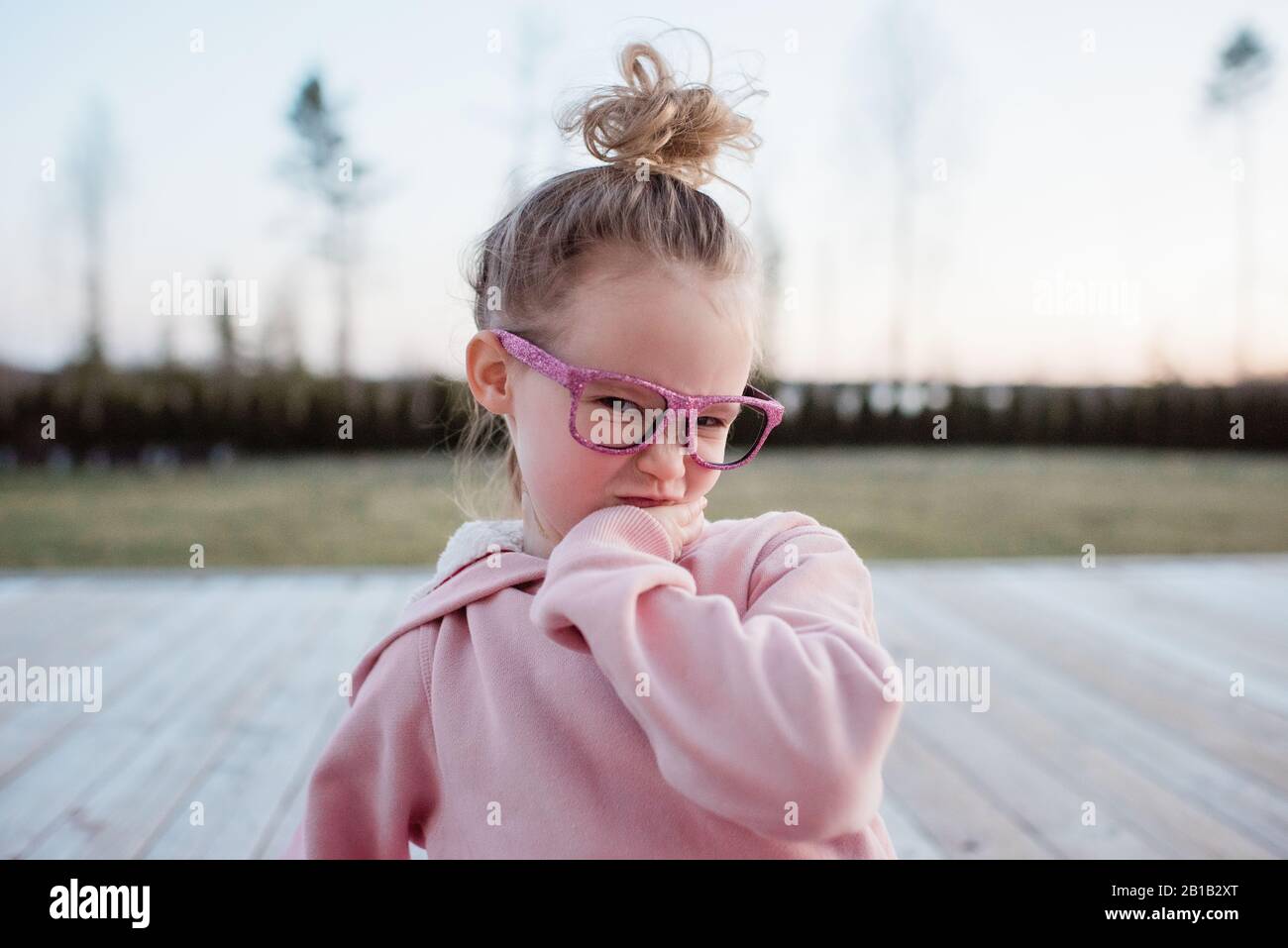 portrait of a young girl pulling funny faces with sparkly glasses on Stock Photo
