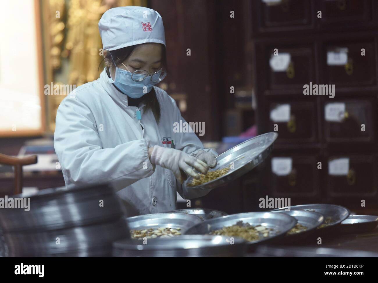 A Chinese employee dispense traditional Chinese herbal medicine (TCM