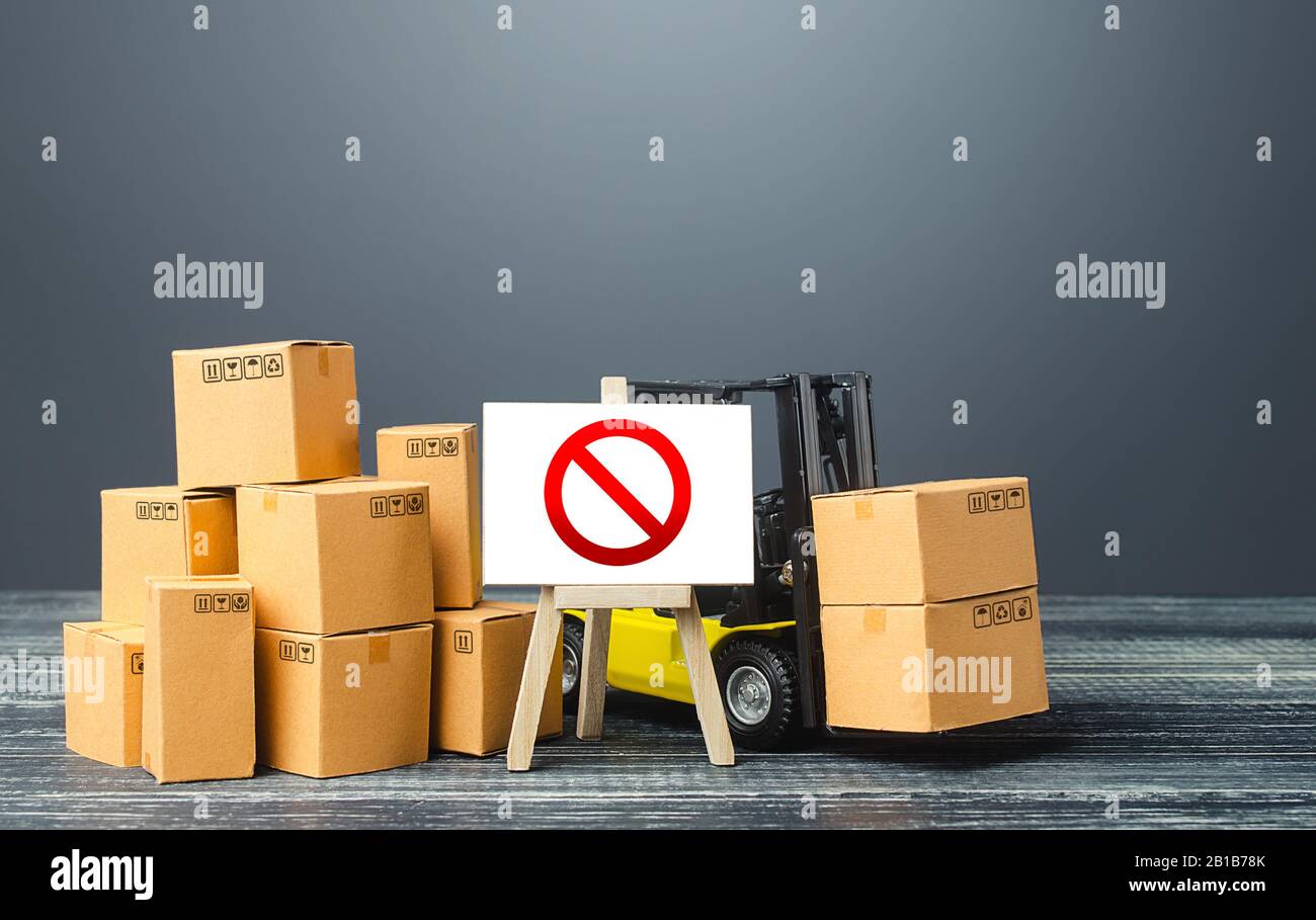 Warehouse with boxes and forklift and easel with prohibition sign NO. Out of stock. Restrictions ban on import goods. Sanctions, trade wars. Isolation Stock Photo
