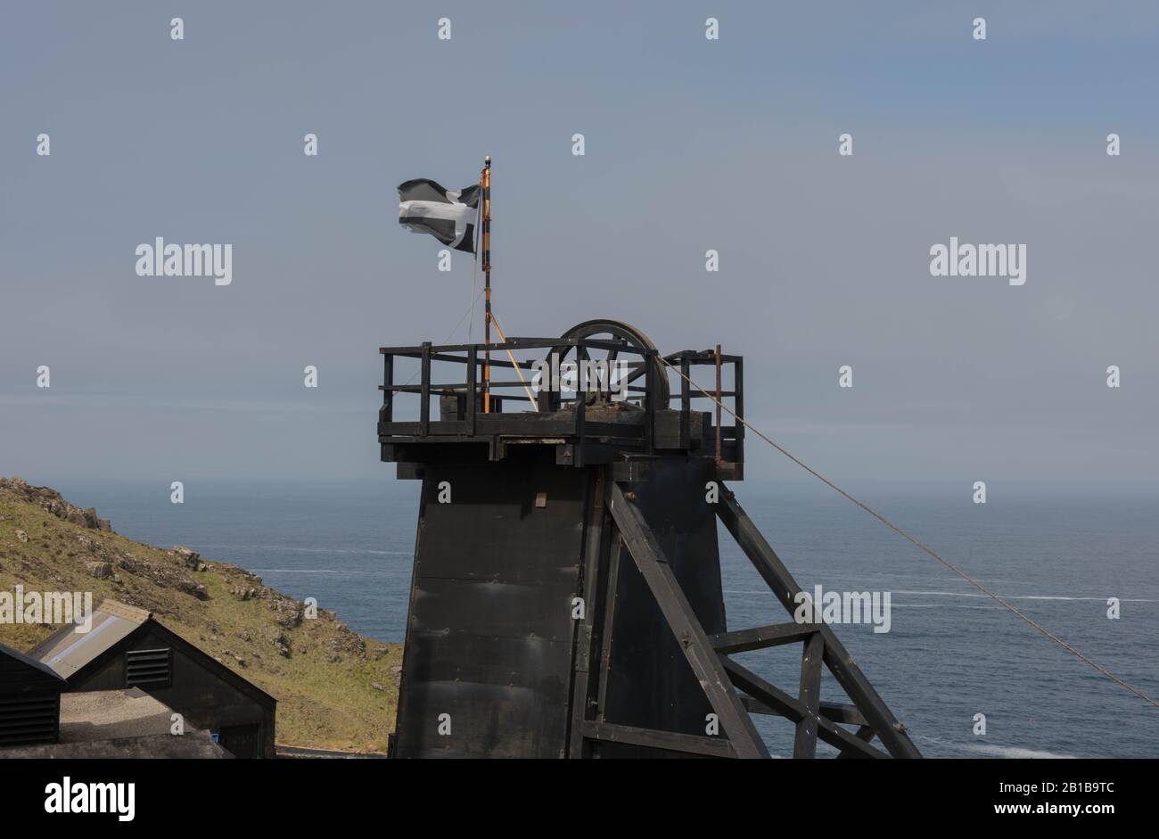 Cornish Flag on Top of a Headframe at the Abandoned Levant Tin Mine on the South West Coast Path in Rural Cornwall, England,UK Stock Photo