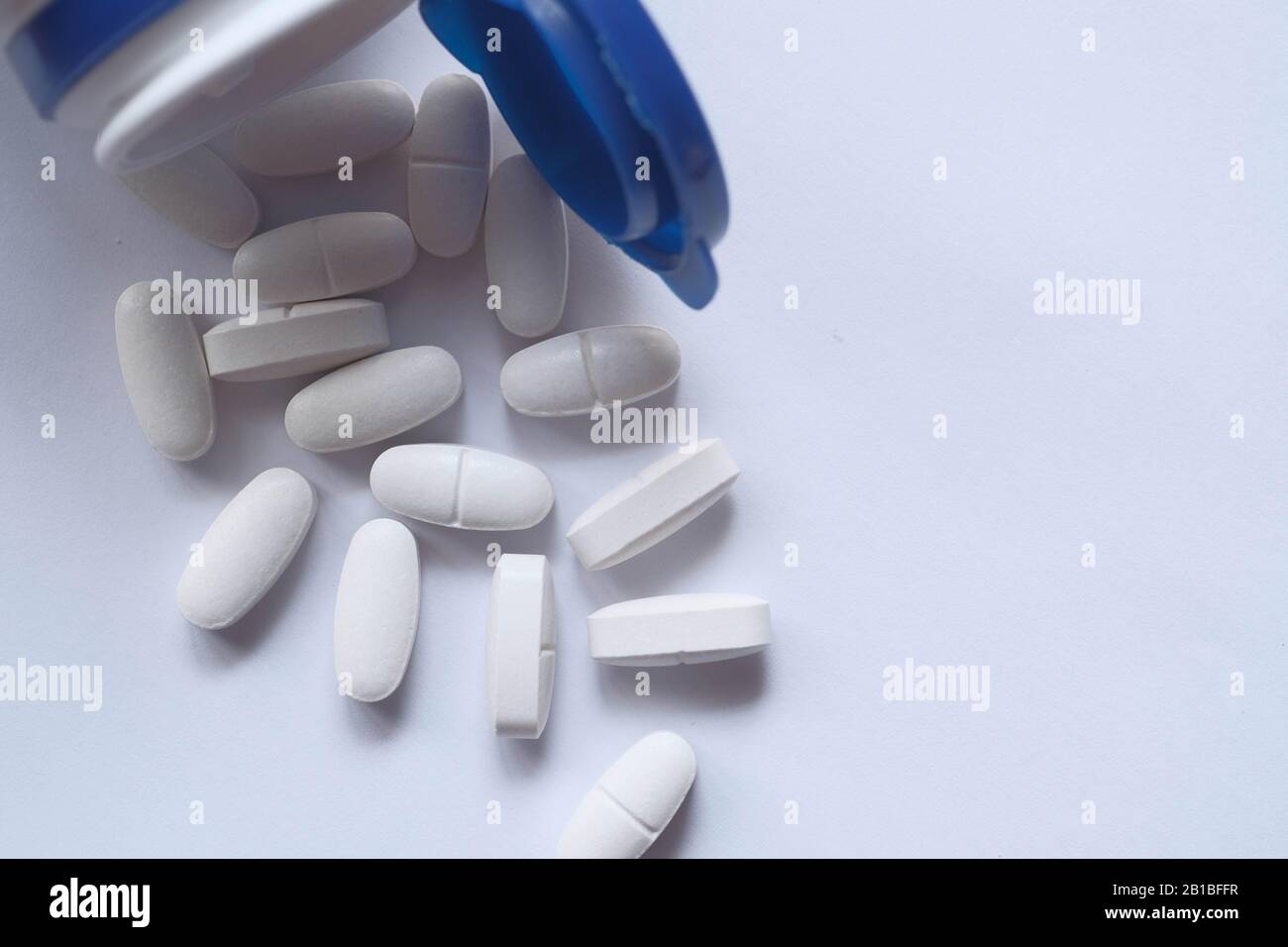 Close up of white pills on table on color background  Stock Photo