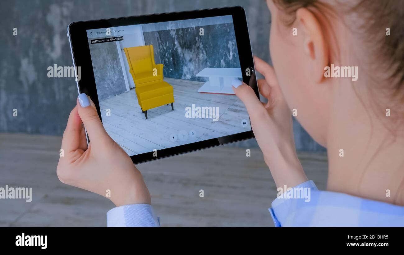Woman using tablet with augmented reality app and placing 3d furniture ...