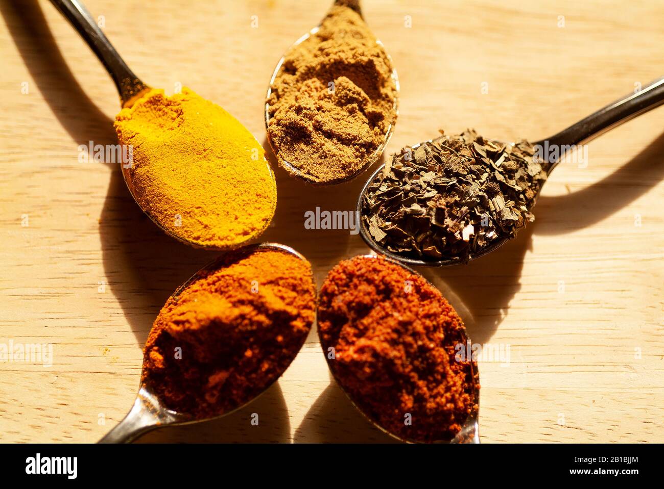 SPICE RACK An arrangement of mini spoons with colorful herbal spices with a garlic clove rest