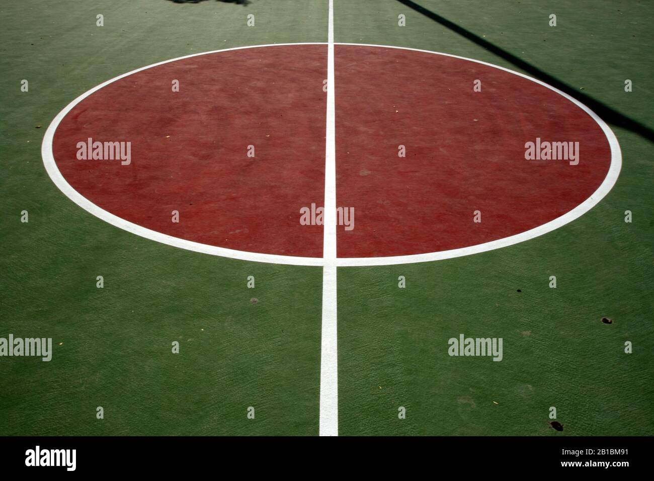 Dubai-Al Barsha Pond Park basket ball court red restraining circle with white midcourt line Stock Photo