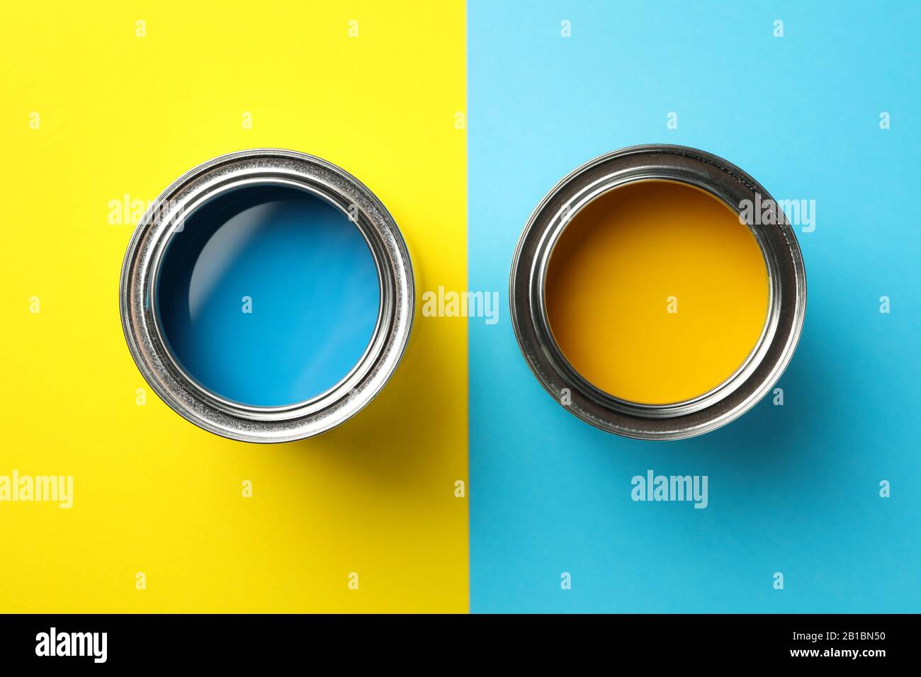 Cans of blue and yellow paint on two tone background, top view Stock Photo