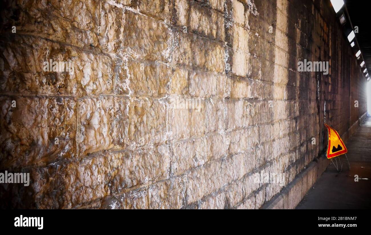 Stone wall with a yellow road plate, Lyon, France Stock Photo