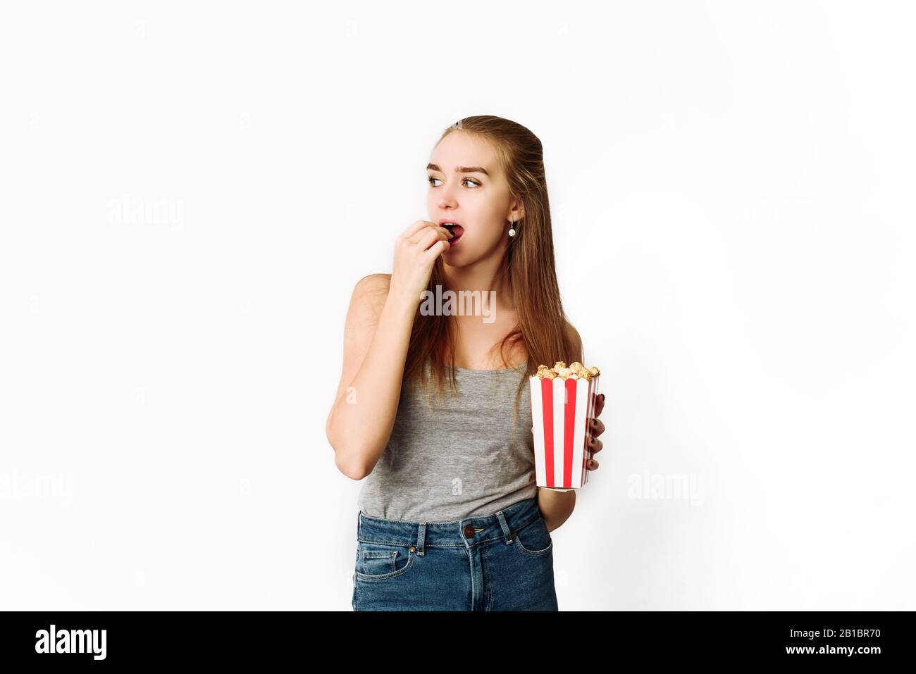 Beautiful blonde girl eat popcorn and watch movie isolated on white  background. Copy Space, template for blog and advertising. Woman hold pop  corn and Stock Photo - Alamy