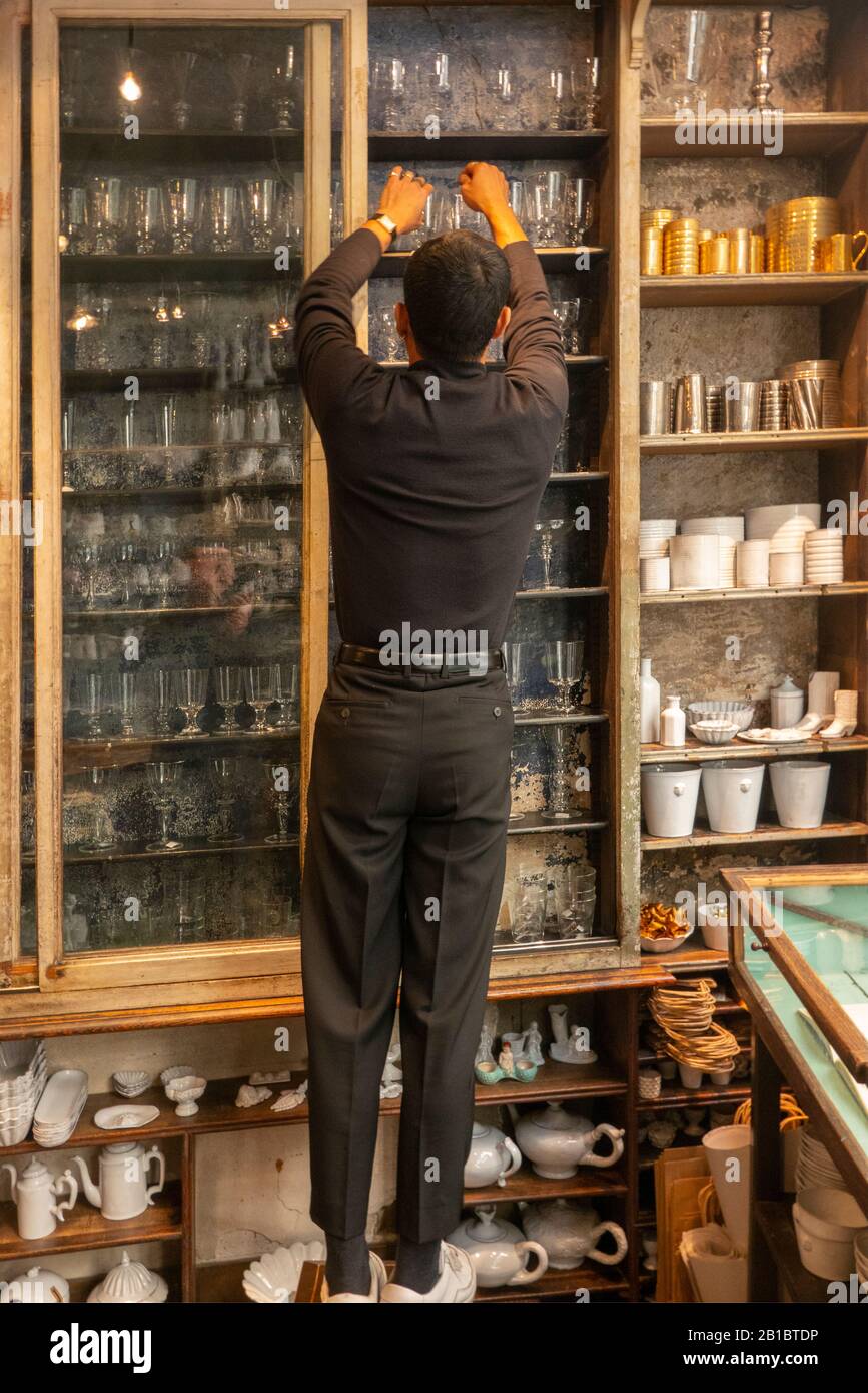 man stocking shelves in Astier de Villatte shop Paris France Stock