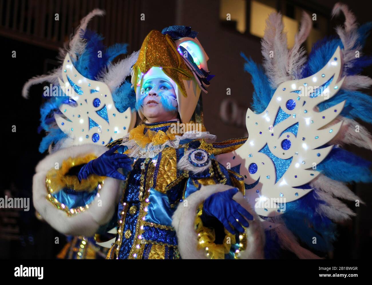 AALST, BELGIUM, 23 FEBRUARY 2020: Unknown carnival participant in bright blue illuminated costume dances in the annual Mardi Gras parade. Stock Photo