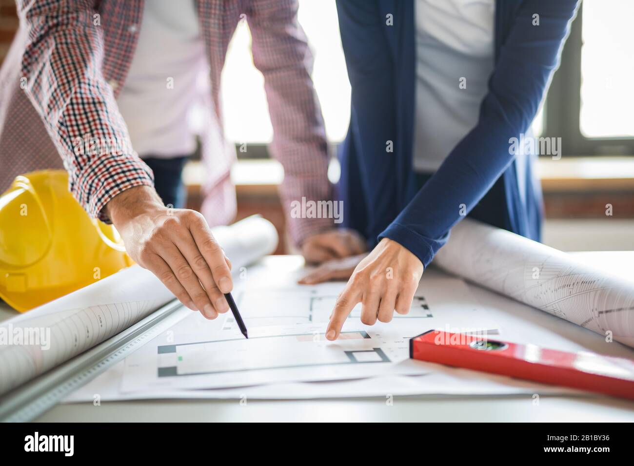 Architects working with blueprints in the office. Teamwork architects concept. Stock Photo