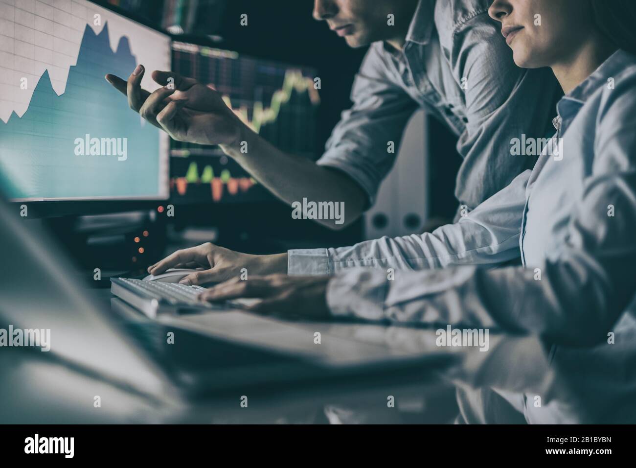 Analyzing data, graphs and reports for investment purposes. Creative teamwork traders. Stock Photo