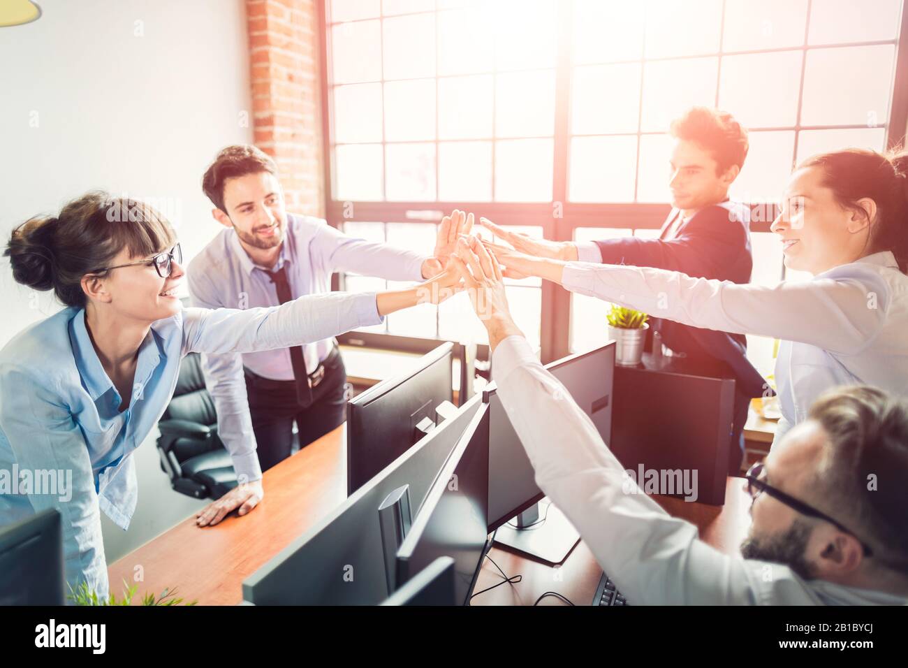 Business people happy showing team work and giving five in office