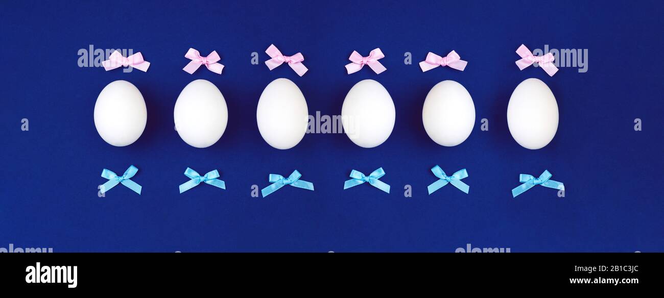 Easter eggs with bows on a blue background. Banner Stock Photo - Alamy