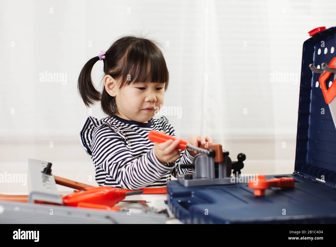toddler girl pretend using DIY tool at home against white background ...