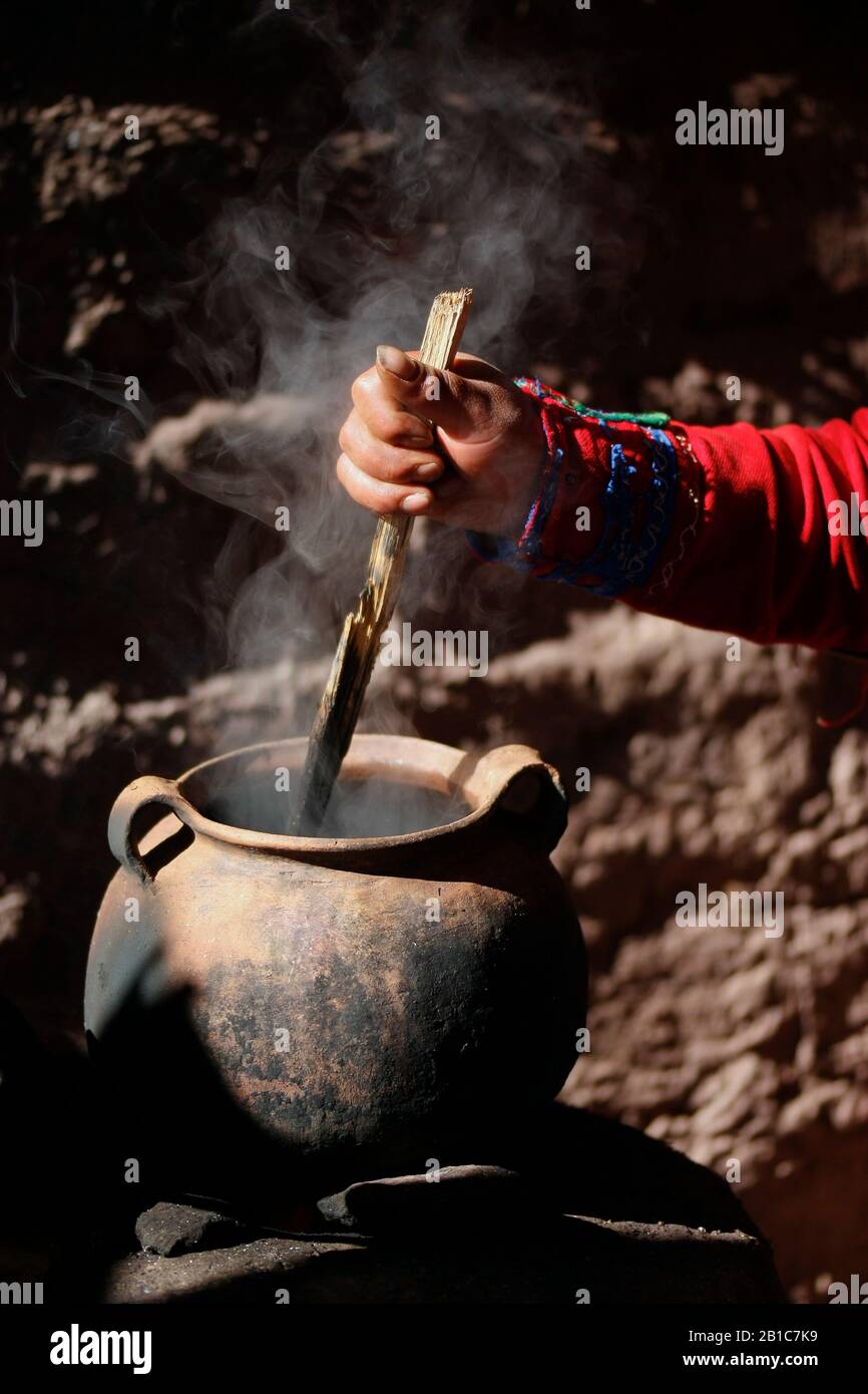 Woman dyeing wool in clay pot for weaving Stock Photo