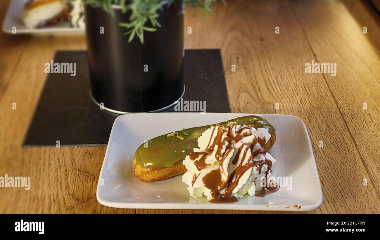 eclair cake on a saucer on a wooden table Stock Photo