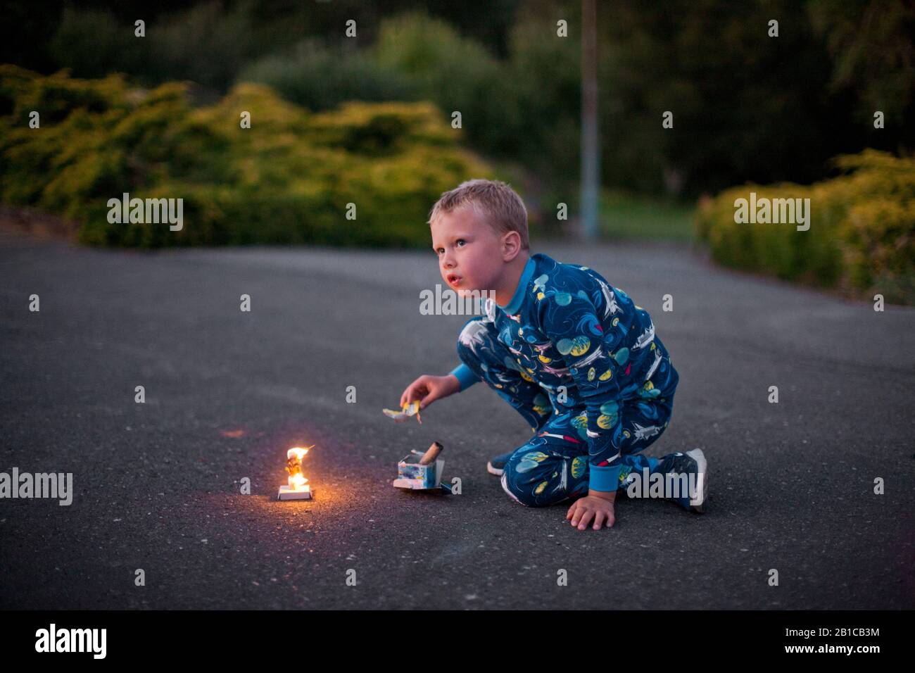 Young boy lighting fireworks on a driveway Stock Photo Alamy