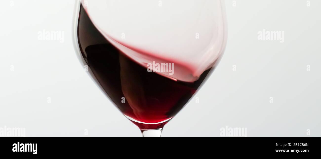 Winery, cheers and winemaking concept Glass of red wine, pouring