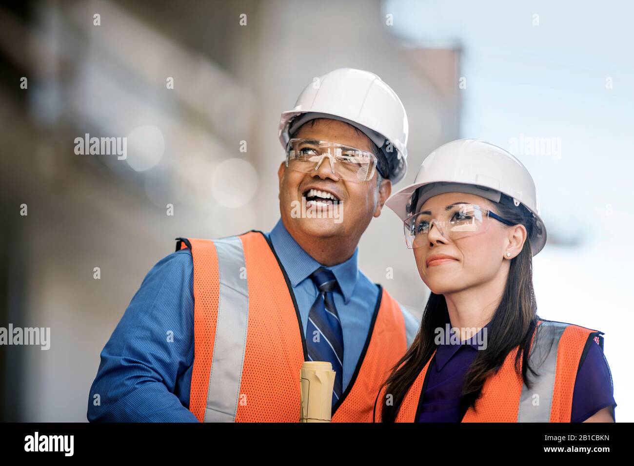 Workers at construction site discuss progress. Stock Photo