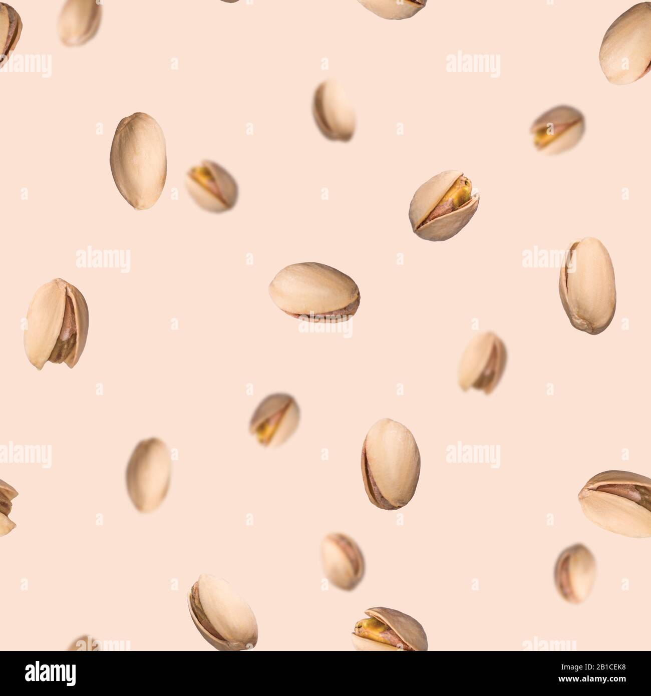Seamless pattern with falling pistachio nuts on beige background. Levity kernels. Stock Photo