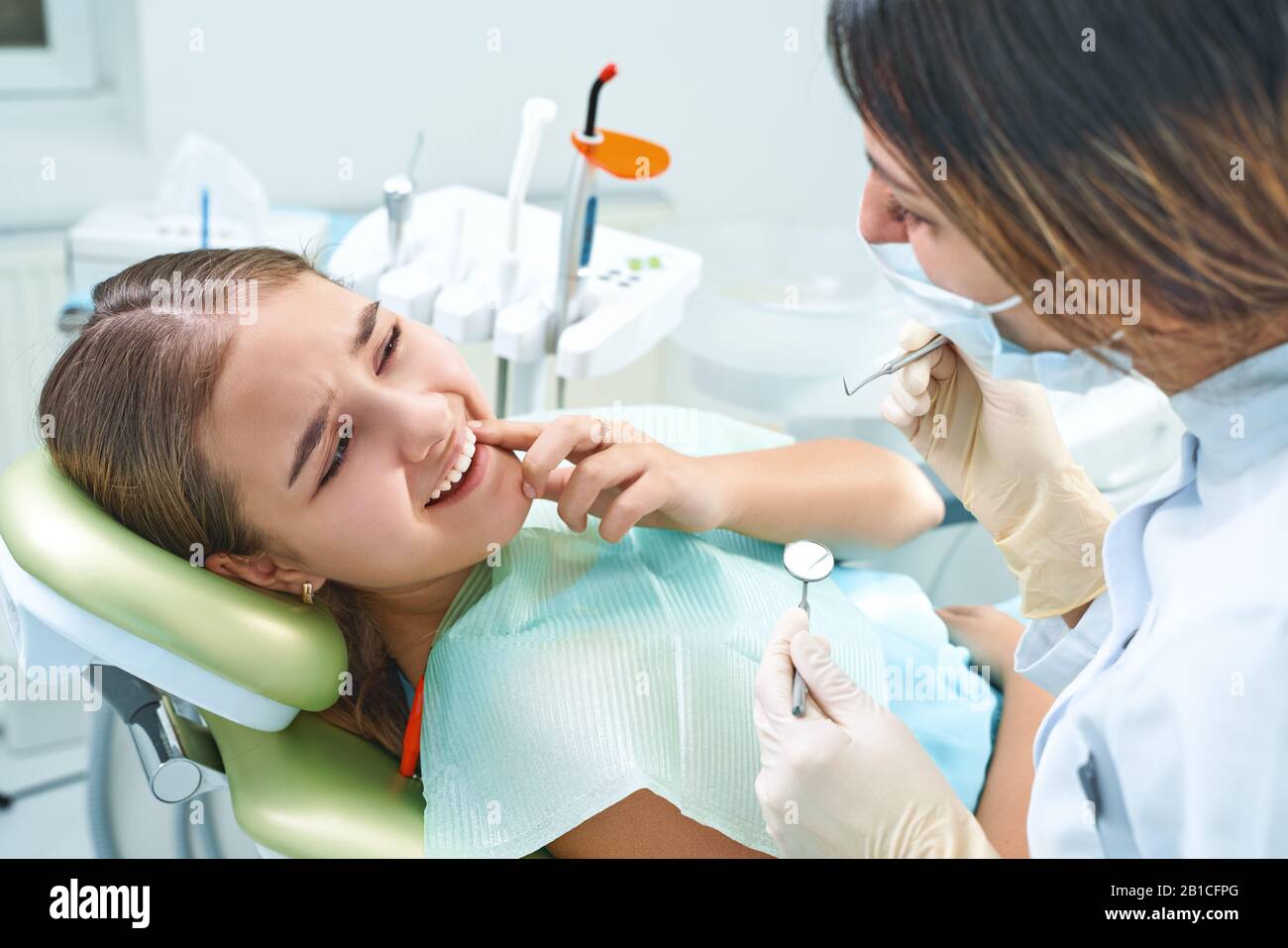 Girl sitting at dental chair with open mouth during oral check up while  doctor. Visiting dentist office. Dentistry concept Stock Photo - Alamy