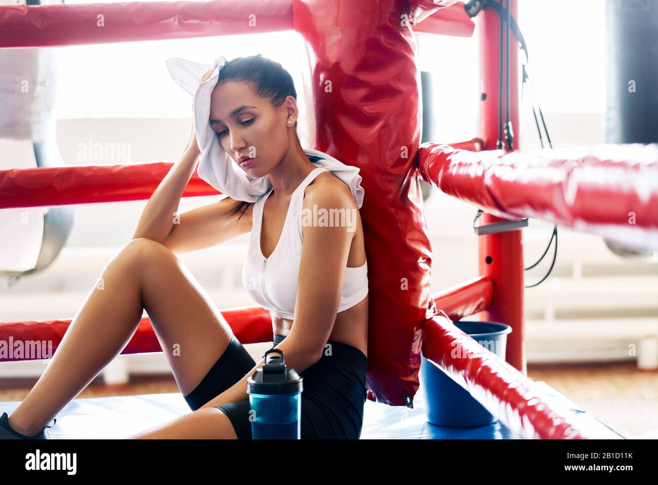 Young beautiful woman relax after fight or workout exercising in boxing ...
