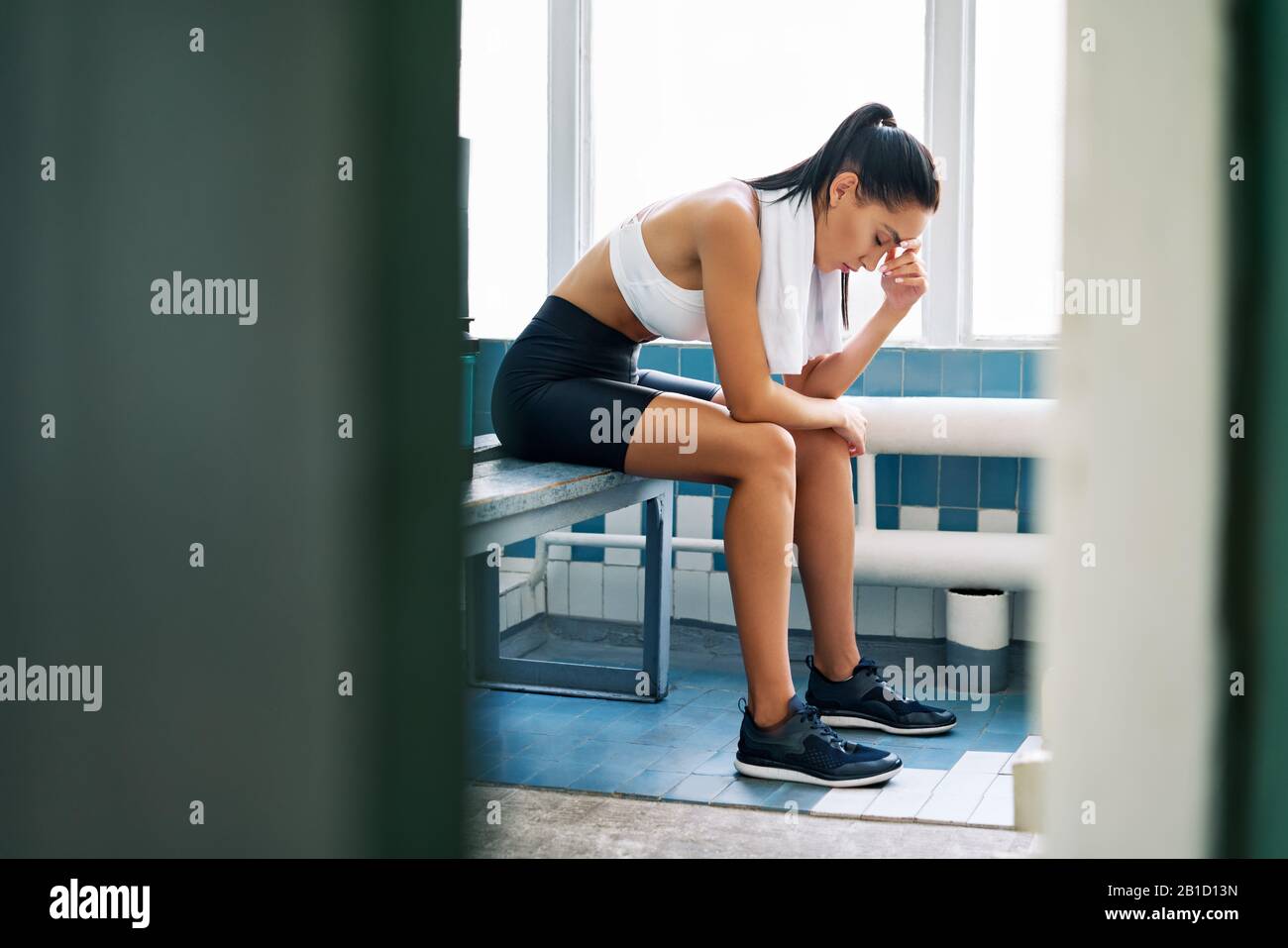 Tired fit woman with a towel in the locker room after hard workout. Stress,  sport, failure concept Stock Photo - Alamy