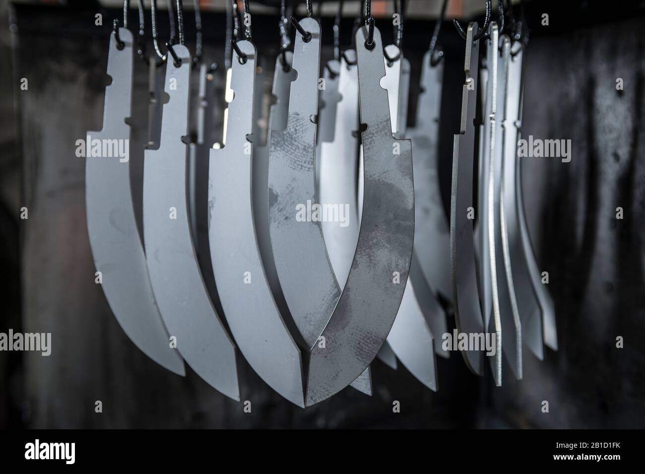 Knife blades hung awaiting tempering Stock Photo Alamy