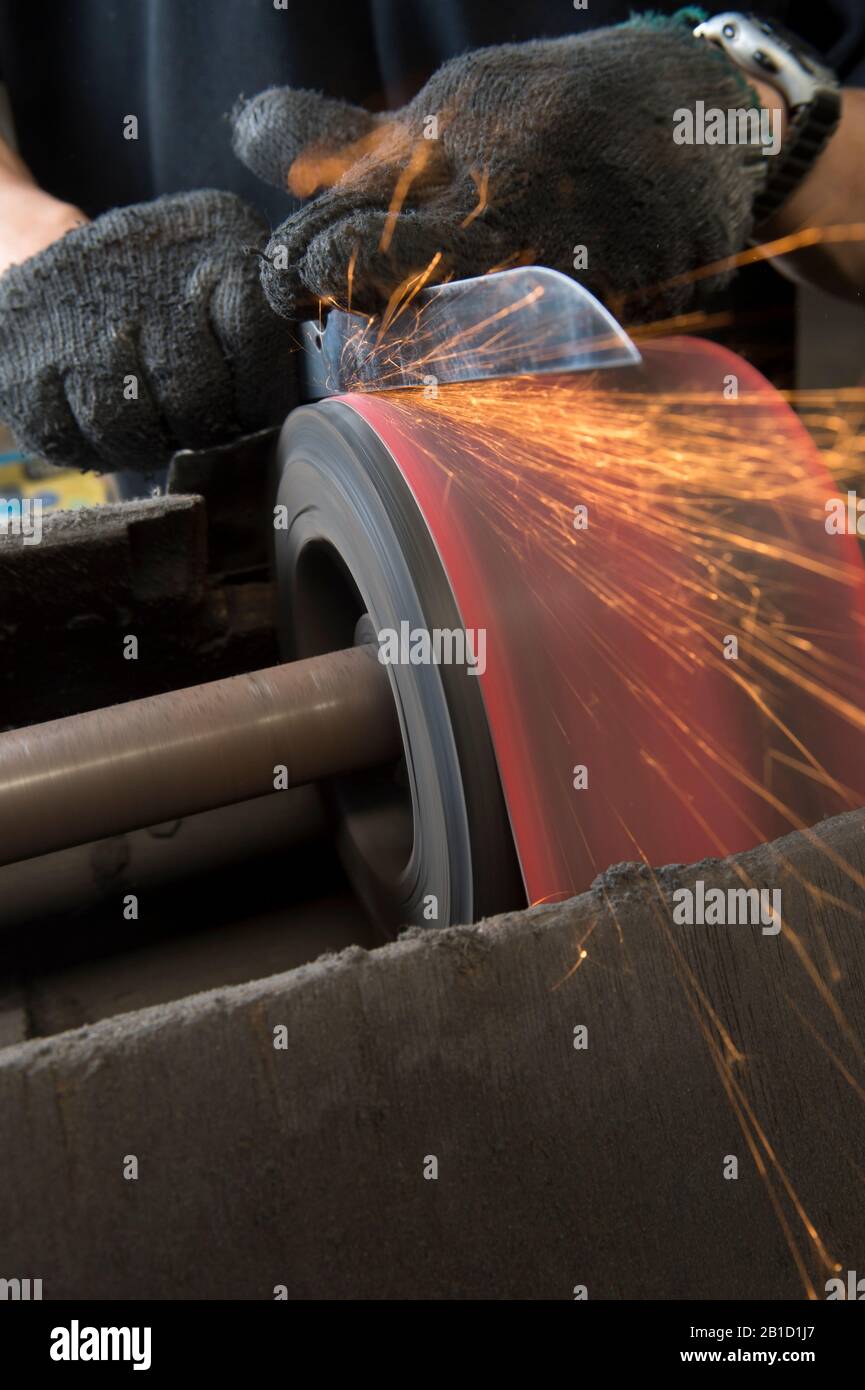Polishing knife blade on sander Stock Photo Alamy